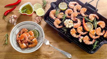Shrimps roasted with lemon slices and garlic  on grill pan.