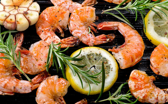Shrimps roasted on grill pan with lemon and rosemary.