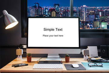 Naklejka premium Graphic designer's workspace equipped with a pen tablet, a computer and white screen for text with beautiful night view city from the window