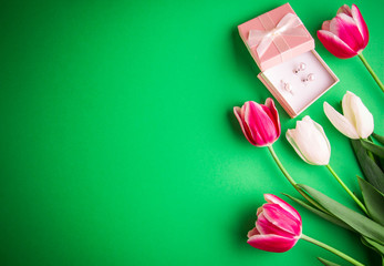 Box with a present with tulips on green background