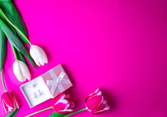 Obraz na płótnie Canvas Box with a present with tulips on purple background