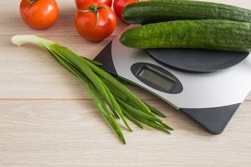 Cucumbers on the weighing scales on the table in the kitchen. Healthy eating and lifestyle.
