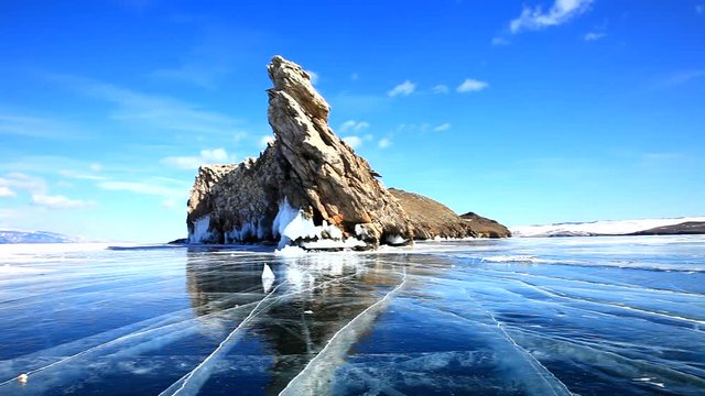 Lake Baikal in March. Rocks the southern tip of the island Ogoy reflected in ice blue surface on a sunny day