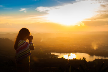 Girl praying on the Mount, thank God. - obrazy, fototapety, plakaty