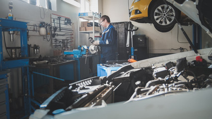 Mechanic in the garage, car preparing for professional diagnostics