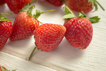 Fresh strawberries on white wooden table.