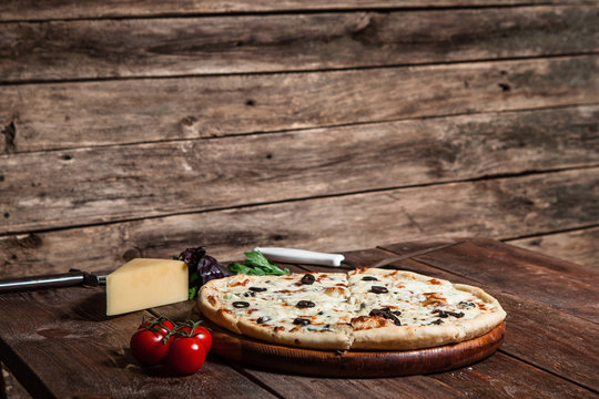 Italian traditional cuisine. Delicious pizza served on wooden table with free space for text.