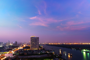 Fototapeta na wymiar Cityscape of Bangkok in twilight viewing Rama III road along Chao Phraya river , Thailand