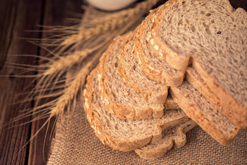 sliced whole wheat bread on wooden table, Vintage dark background.