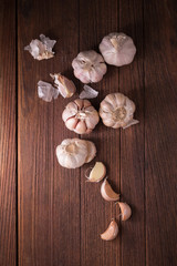 Garlic and garlic press on rustic wooden board.