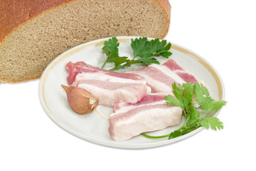 Sliced uncooked bacon with greens on the background of bread