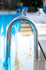 Shiny stainless steel pool entrance to outdoor pool in holiday resort