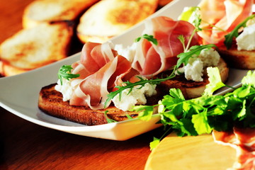 Bruschetta with ricotta, prosciutto, rucola