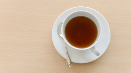 Top view of a cup of hot tea on wooden table