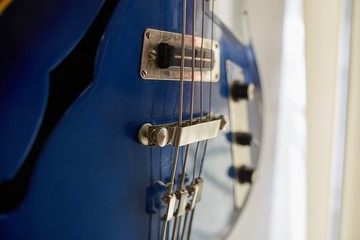  Old excellent electro and bass guitars on the shelf in the guitar shop