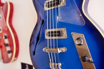  Old excellent electro and bass guitars on the shelf in the guitar shop