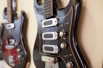  Old excellent electro and bass guitars on the shelf in the guitar shop