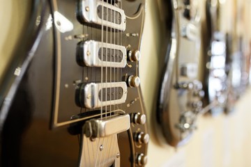  Old excellent electro and bass guitars on the shelf in the guitar shop