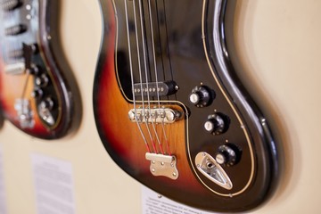  Old excellent electro and bass guitars on the shelf in the guitar shop