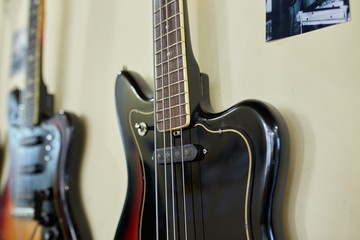  Old excellent electro and bass guitars on the shelf in the guitar shop