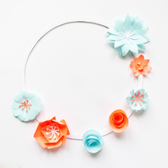 Round frame with color paper flowers on white background. Cut from paper.