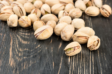 Scattered pistachio nuts on a wooden table