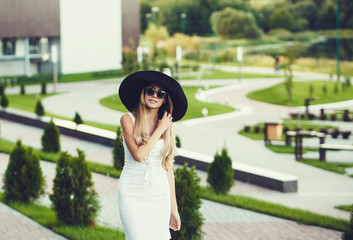 Beautiful woman in sunglasses and hat in the park