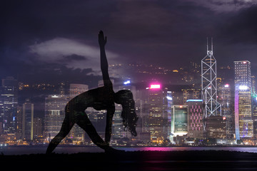 Double exposure of Silhouette yoga woman against Hong Kong city