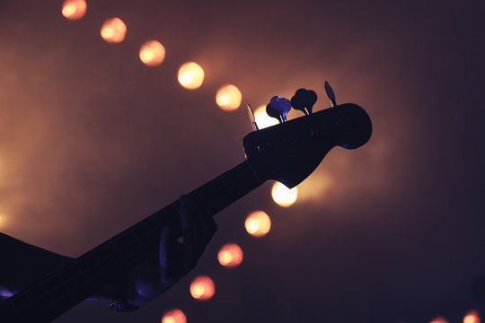 Bass guitar over bright blurred lights