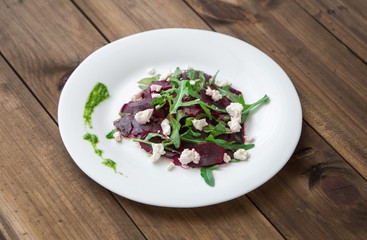 Salad with beet, feta, arugula and pesto.
