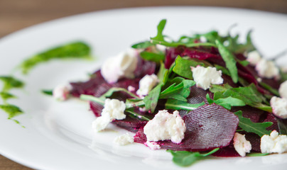 Salad with beet, feta, arugula and pesto.
