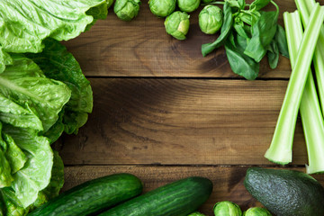 Products containing folic acid - B9 vitamin . Green vegetables on wooden background. Celery, avocado, Brussels sprouts, basil, cucumber, romaine salad