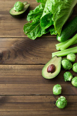 Products containing folic acid - B9 vitamin . Green vegetables on wooden background. Celery, avocado, Brussels sprouts, romaine salad cucumber. space for text