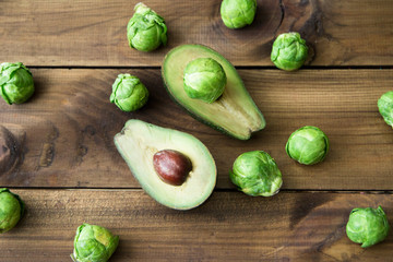 Products containing folic acid - B9 vitamin . avocado and Brussels sprouts on wooden background.