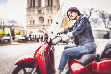 Fototapeta na wymiar Young Chinese Female On Scooter In Paris