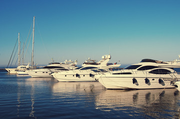 Fototapeta premium White yacht in the port waiting. On the sea is calm.