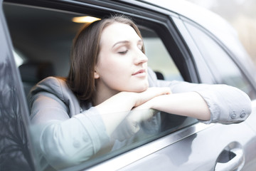 Fototapeta na wymiar Woman sitting in car, leaning out of window