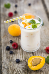 Smoothies or yogurt with fresh berries on a wooden table.