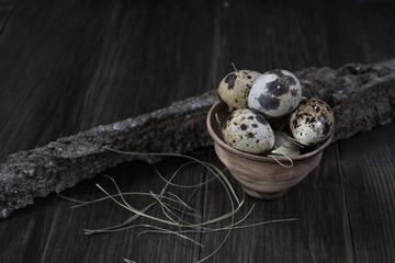 Quail eggs in clay pot on dark background. Eco products. Healthy food 
