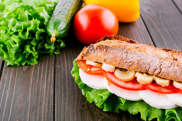 Fresh vegetables, salad, eggs and mushrooms lie between pieces of crusty wholemeal bread