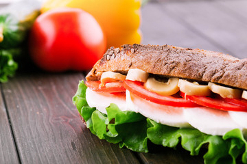 Crusty wholemeal bread sandwich with mushrooms, tomatoes, eggs and salad