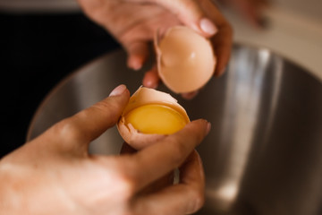 Hand break an egg and pouring into bowl. Key ingredient for tasty omelet and separates albumen from...