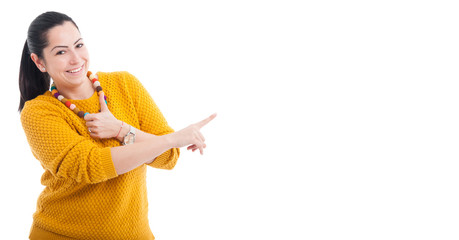 Smiling woman pointing finger on copy space