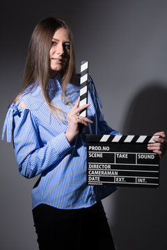 Young woman in a striped shirt with movie clapper.