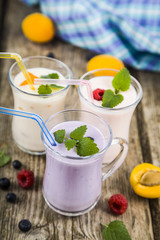Smoothies or yogurt with fresh berries on a wooden table.