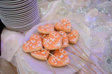 Cookies with newlyweds initials lie on white plate