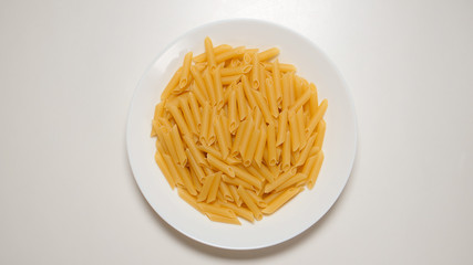TOP VIEW: Macaroni on a white dish on a white table