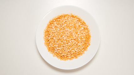 TOP VIEW: Dried yellow peas on a white dish