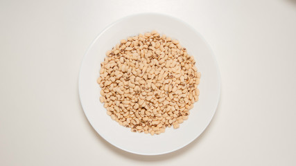 TOP VIEW: Dried white beans on a white dish