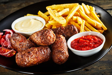 Deep fried cevapcici meat patties and potato chips
